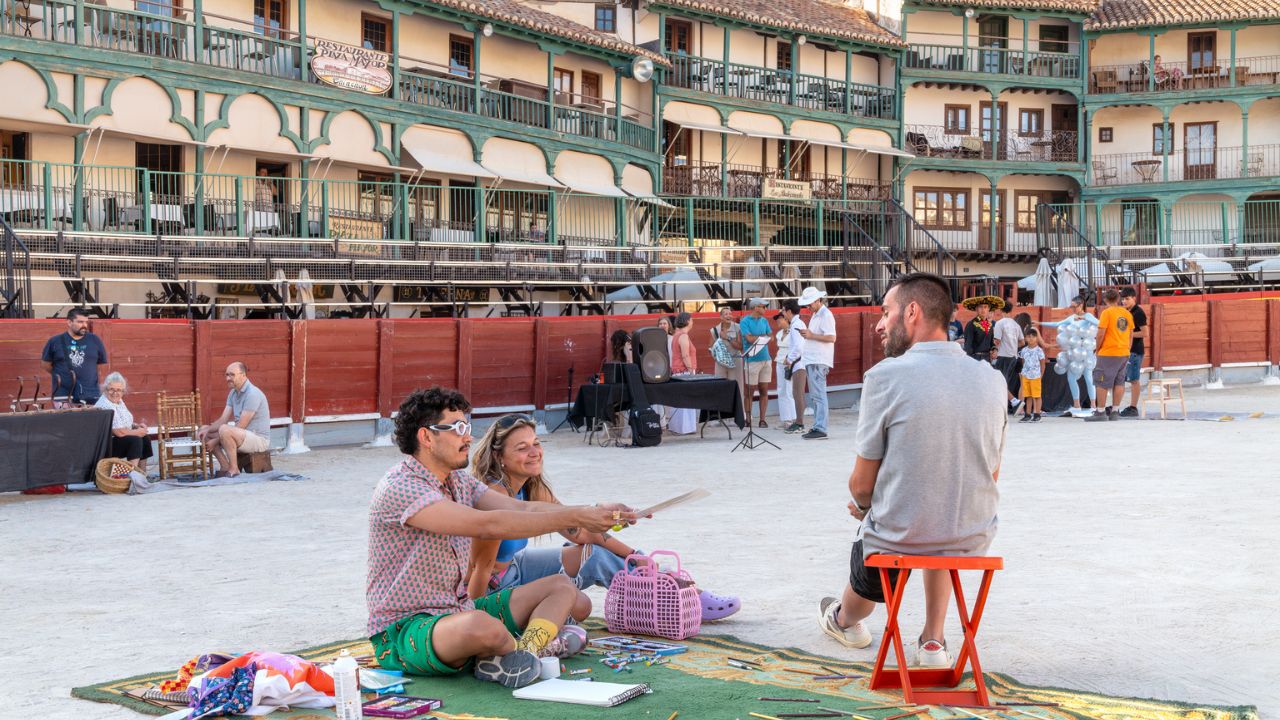 Artistas y público participando en actividades creativas en una plaza dentro del curso cultural.