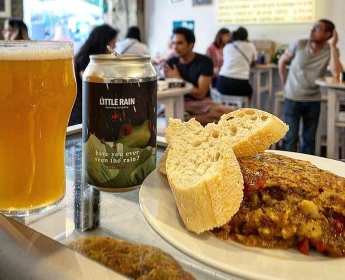 Foto de una tortilla y una cerveza en el local donde hay gente de Pez Tortilla