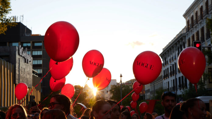 vogue-234 Multitud con globos rojos durante la Vogue Fashion’s Night Out en Madrid, con ambiente festivo frente al cartel de Vogue.